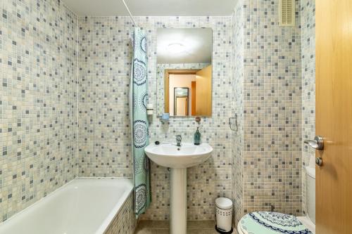 a bathroom with a sink and a tub and a mirror at Casares del Sol Apartment in Casares