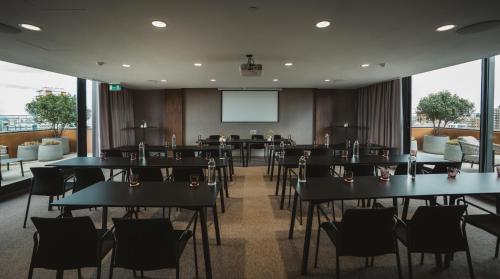 a dining room with tables and chairs and a screen at Hotel Pinar Plaza in Madrid