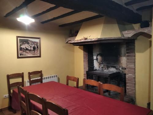 a dining room with a table and a fireplace at Casa la Cisterna in Pina de Montolgrao