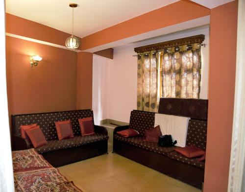 uma sala de estar com duas camas e uma janela em Pemathang Hotel em Gangtok