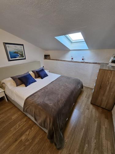 a bedroom with a large bed with blue pillows at Adria Pearl Appartments in Vrsar