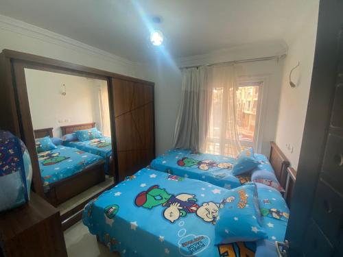 a bedroom with two twin beds and a mirror at Luxurious, fully furnished and well equipped apartment with modern amenities, stunning views, and convenient location for remote work or studying from home in Madinaty