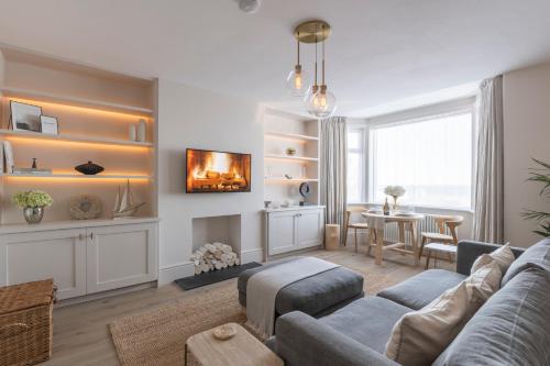 a living room with a couch and a table at Blu's Seaview Apartment in Llandrillo-yn-Rhôs