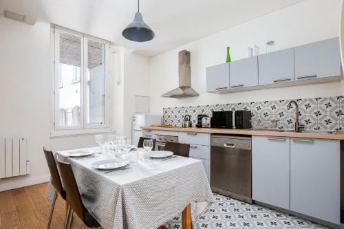 une cuisine avec une table recouverte d'une nappe dans l'établissement Espace et lumière - T3 - Palais de Justice, à Toulouse