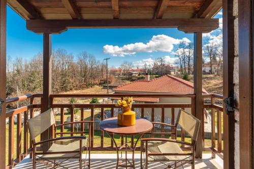 un patio avec une table et des chaises sur un balcon dans l'établissement hostel lake plastira, à Kalyvia