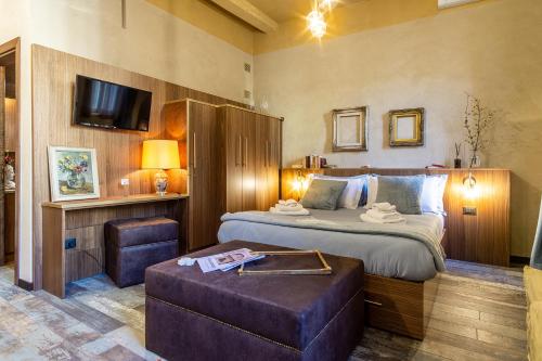 a bedroom with a bed with a ottoman and a television at Dependance Cara Giulietta in Verona
