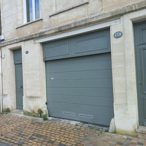 une porte de garage sur le côté du bâtiment dans l'établissement Bordeaux Chartrons superbe T2 avec terrasse, à Bordeaux