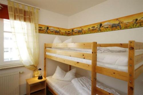 a bedroom with two bunk beds and a window at Strandschloesschen-Haus-II-WE-17-9871 in Kühlungsborn