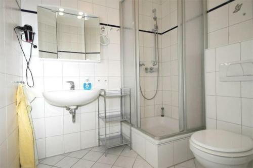 a bathroom with a shower and a toilet and a sink at Strandschloesschen-Haus-II-WE-17-9871 in Kühlungsborn