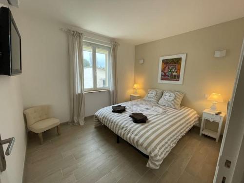 a bedroom with a bed with a striped comforter and a window at Charmante maison 2 chambres avec cour et jardin in Sainte-Savine