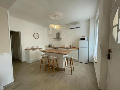 - une cuisine avec une table et des tabourets dans l'établissement Charmante maison 2 chambres avec cour et jardin, à Sainte-Savine