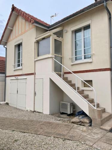 a house with a staircase in front of it at Charmante maison 2 chambres avec cour et jardin in Sainte-Savine