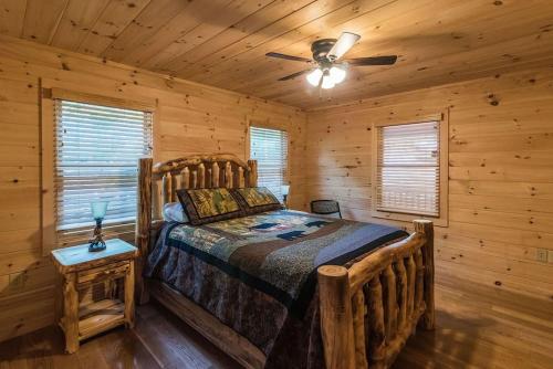 a bedroom with a bed in a log cabin at Majestic mountaintop cabin, hot tub, fireplaces in Craytonia
