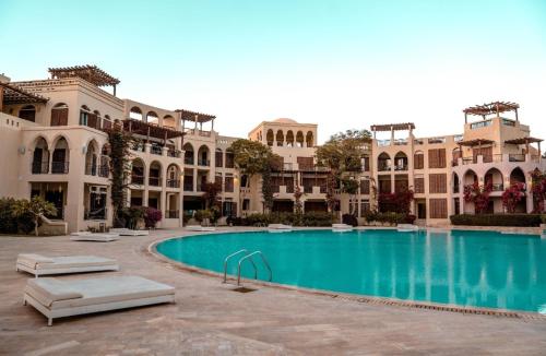 un complejo con piscina frente a un edificio en Family Sweet - Apartment in Tala Bay Aqaba, en Al Burj
