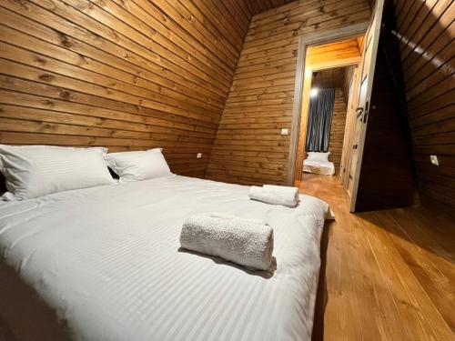 a bedroom with a large bed in a wooden room at Gudauri Sikhaura in Kʼumlistsʼikhe