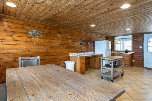 uma cozinha com paredes de madeira e uma mesa de madeira em 2 Units on Fife Lake with Hot Tub-Sleeps 14 em Fife Lake