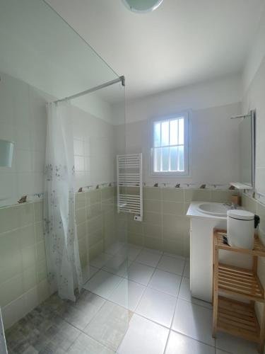 une salle de bain blanche avec une douche et un lavabo dans l'établissement Vacances au Chateau d'Oléron, au Château-dʼOléron