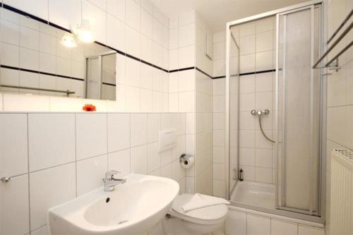 a bathroom with a sink and a toilet and a shower at Strandschloesschen-Haus-II-WE-23-9743 in Kühlungsborn