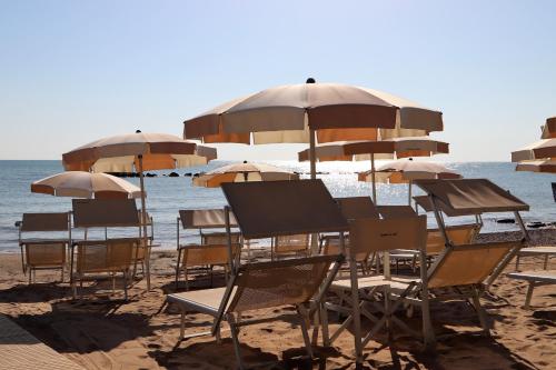 a group of chairs and umbrellas on a beach at Residence Ada in Grottammare