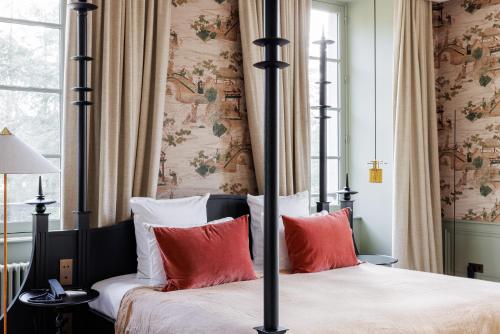 a bedroom with two beds with red pillows at Domaine de Locguénolé & Spa - Relais & Chateaux in Kervignac