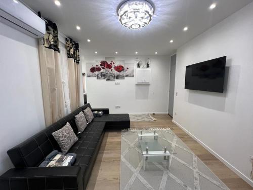 a living room with a black couch and a glass table at Appartement T2 in Nice