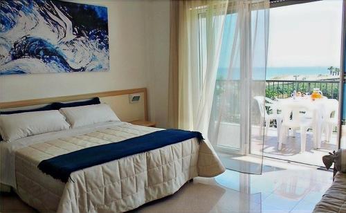 a bedroom with a bed and a view of a table at Residence Ada in Grottammare