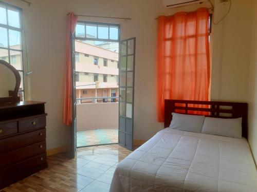 a bedroom with a bed and a window and a dresser at Hotel City Central Guayaquil in Guayaquil