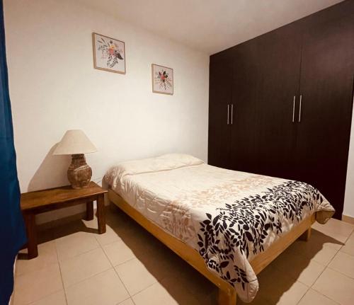 1 dormitorio con 1 cama y 1 mesa con lámpara en Departamento completo y nuevo, en San Luis Potosí