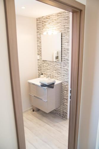 a bathroom with a sink and a mirror at L’Été en Novembre in Kirrwiller