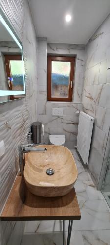 a bathroom with a wooden sink and marble walls at aNNa s Cozy Home with Private Forest, Canopy Terrace & Parking, near Red Bull Ring in Sankt Michael in Obersteiermark