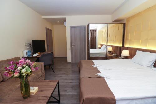 een hotelkamer met een groot bed en een bank bij MANDARIN Hotel in Jerevan