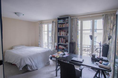une chambre avec un lit et un bureau avec un ordinateur dans l'établissement Amazing flat 3 bedrooms Notre Dame, à Paris