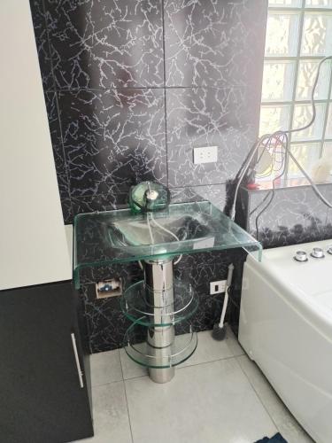 a glass counter in a bathroom with a sink at Habitación con jacuzzi, amoblado cama 3 plazas, escritorio, ropero y baño propio in Huancayo