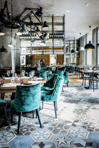 a restaurant with turquoise chairs and tables at Hotel Lilla Roberts in Helsinki