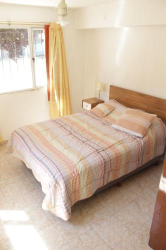 1 dormitorio con cama y ventana en El Arrayan Departamento en Esquel