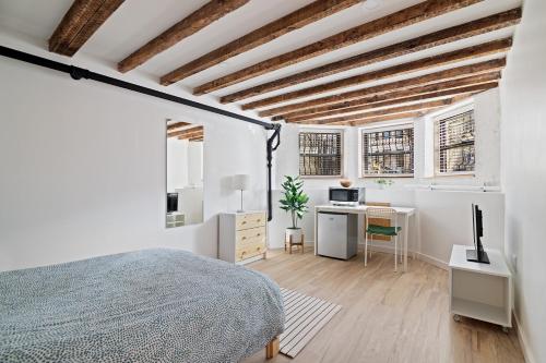 ブルックリンにあるCozy, Large and Fully Furnished - Near the L Trainのベッドルーム1室(ベッド1台、デスク、コンピュータ付)