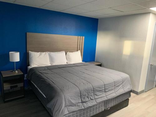 a bedroom with a large bed with a blue wall at JAL COUNTRY INN in Jal