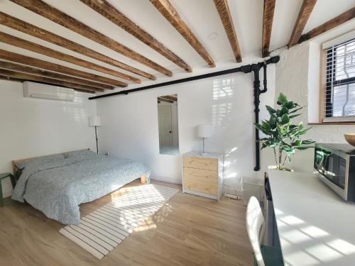 1 dormitorio con 1 cama en una habitación con paredes blancas en Cozy, Large and Fully Furnished - Near the L Train, en Brooklyn