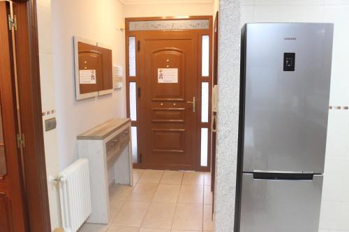 eine Küche mit einem Kühlschrank neben einer Tür in der Unterkunft Casa Maria in Bueu