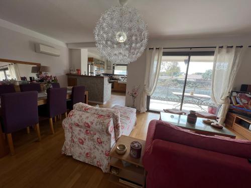 - un salon avec un canapé et un lustre dans l'établissement APPARTEMENT STANDING AJACCIO 5mn A PIEDS PLAGE DU RICANTO AJACCIO, à Ajaccio