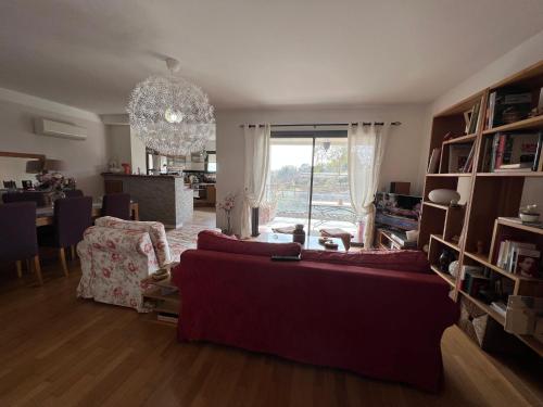 - un salon avec un canapé rouge et une salle à manger dans l'établissement APPARTEMENT STANDING AJACCIO 5mn A PIEDS PLAGE DU RICANTO AJACCIO, à Ajaccio