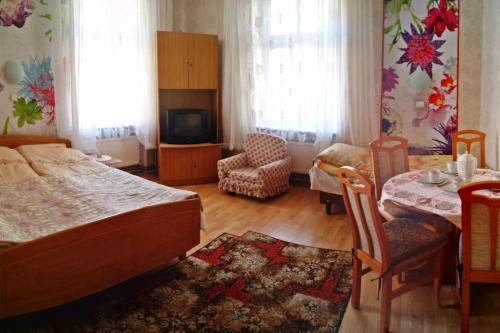 a bedroom with a bed and a table and a tv at Apartament w Willi Lemoniada in Ustka