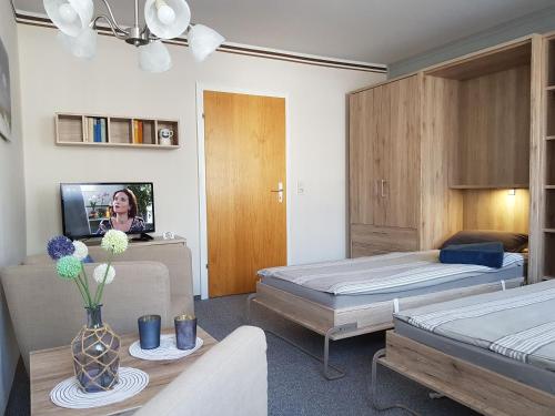 a hotel room with two beds and a tv at Haus Lieberum Apartment Erdgeschoß in Bad Sooden-Allendorf
