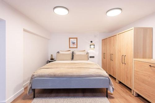 um quarto com uma cama grande e um armário de madeira em City Sky Loft in Vilnius em Vilnius