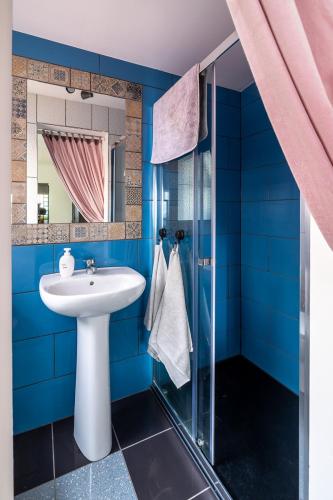a bathroom with a sink and a glass shower at Panoramic House in Ribeira Brava