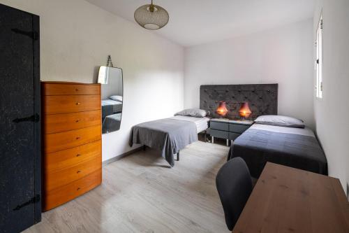 a bedroom with two beds and a dresser with two lamps at Panoramic House in Quinta do Almeida