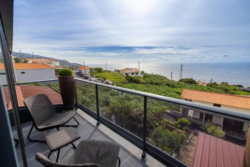 a balcony with two chairs and a view of the ocean at Panoramic House in Ribeira Brava