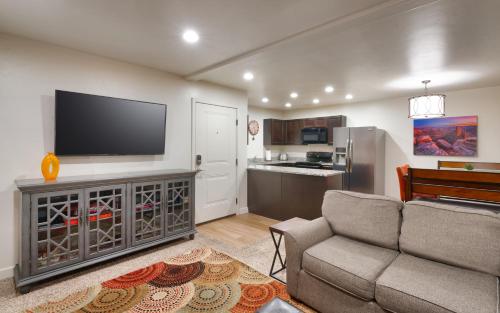 sala de estar con sofá y TV de pantalla plana en 6A Family Friendly RedCliff Condo POOL & HOT TUB (Pet Friendly), en Moab