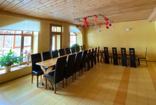 a dining room with a long table and chairs at Dzintara Pirts in Vigale