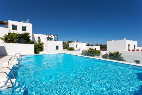 a swimming pool in front of a villa at Plakoti Village in Maroulás